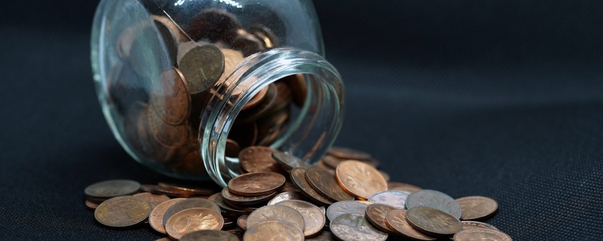 A round jar of pennies spills over