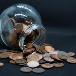 A round jar of pennies spills over