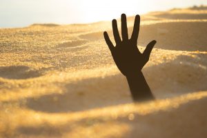 hand reaching out of quicksand
