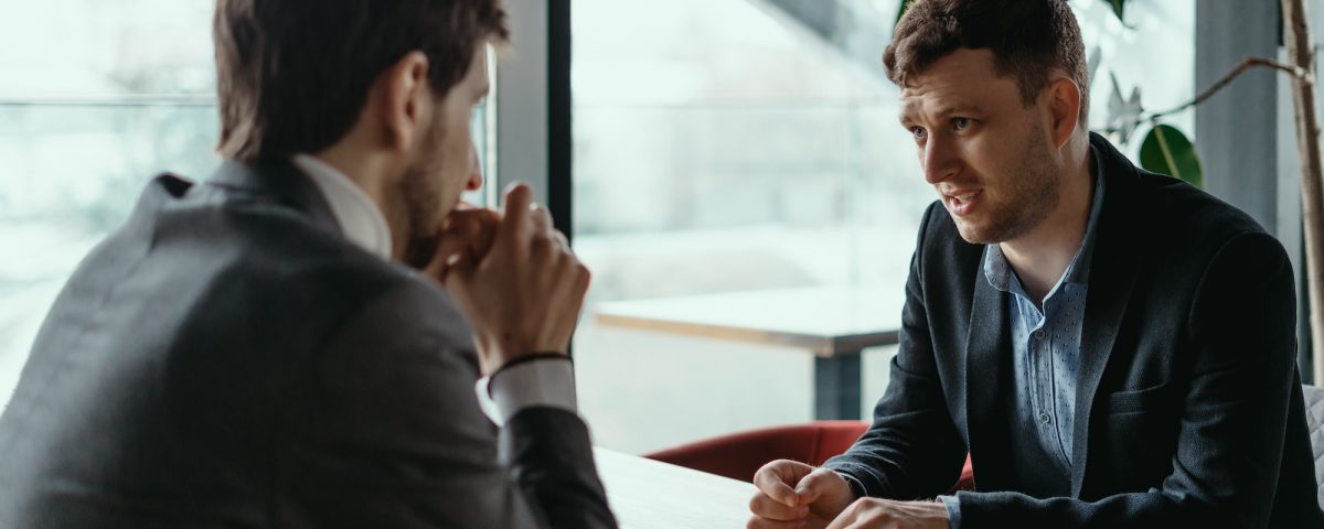 two businessmen having serious discussion in cafe