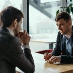 two businessmen having serious discussion in cafe