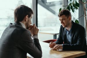 two businessmen having serious discussion in cafe