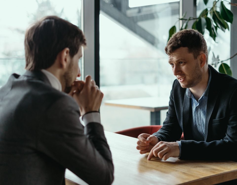 two businessmen having serious discussion in cafe