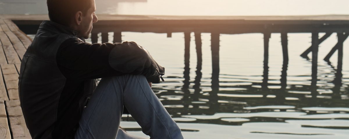 Man looking at lake in contemplation