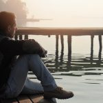 Man looking at lake in contemplation