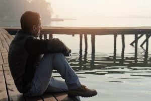 Man looking at lake in contemplation